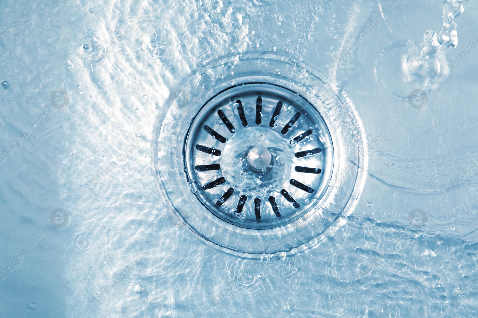 Photo of Water going down sink drain, top view