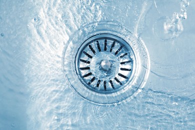 Photo of Water going down sink drain, top view