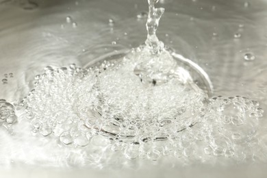 Photo of Water going down sink drain, closeup view