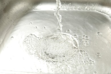 Photo of Water going down sink drain, closeup view