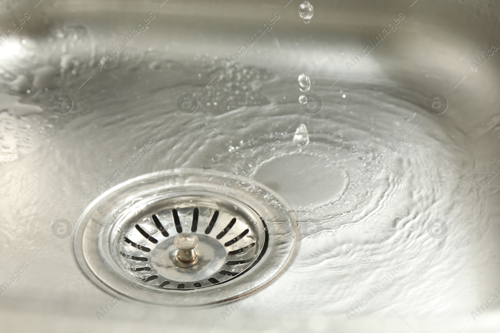 Water going down sink drain, closeup view Photo of Water going down sink drain, closeup view