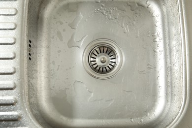 Photo of Water going down sink drain, top view