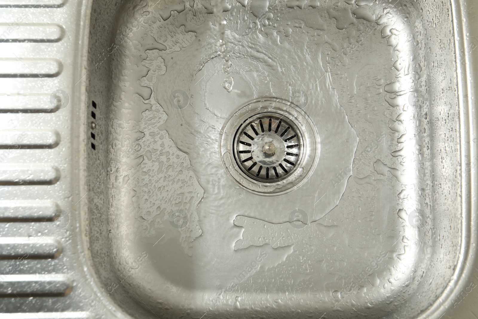 Photo of Water going down sink drain, top view