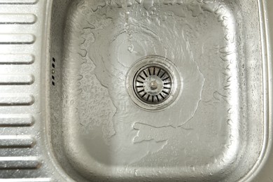 Photo of Water going down sink drain, top view
