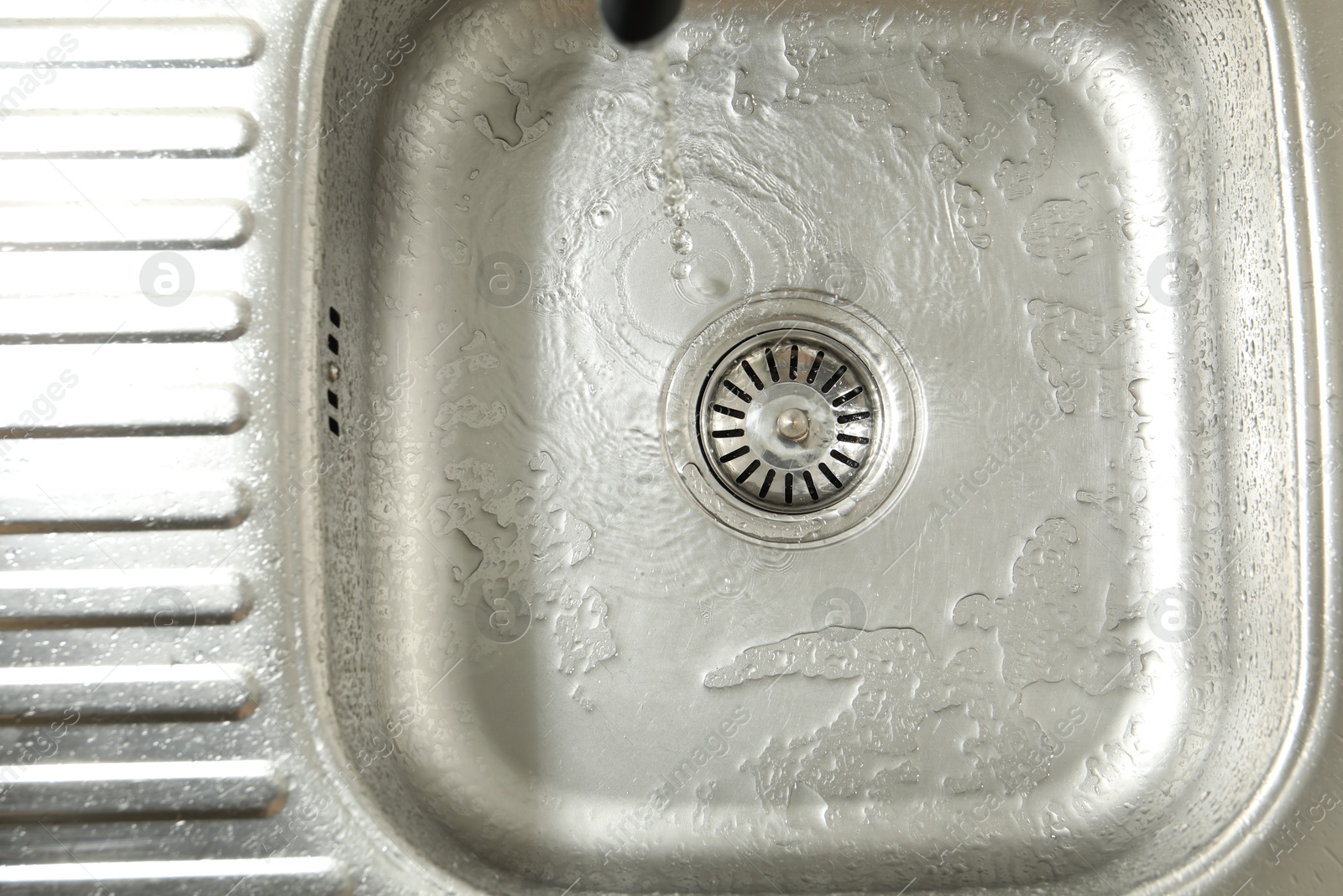 Photo of Water going down sink drain, top view