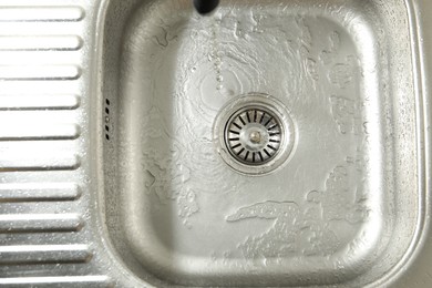 Photo of Water going down sink drain, top view
