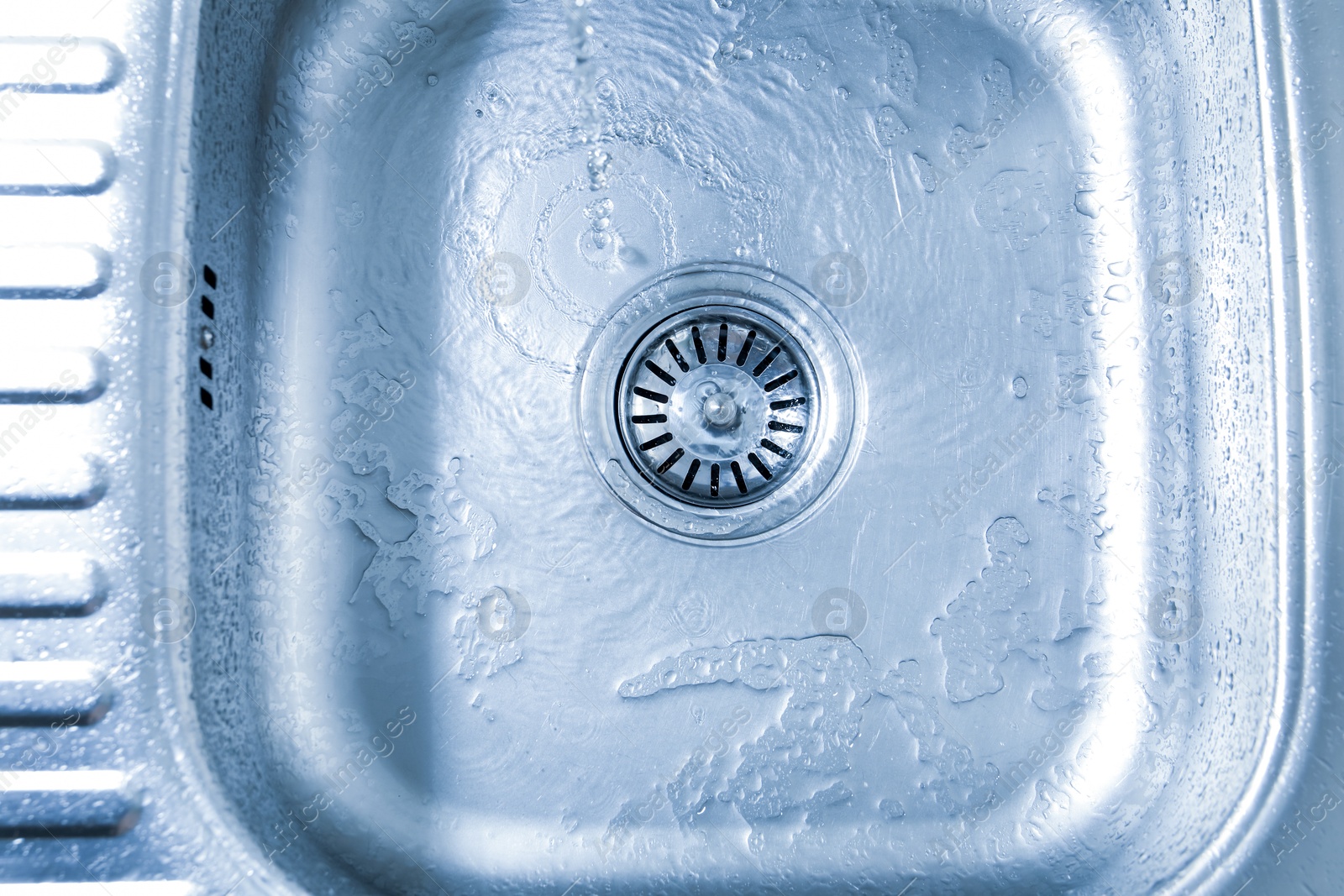 Photo of Water going down sink drain, top view
