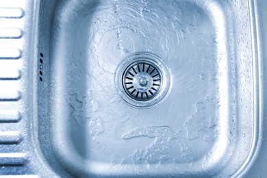 Photo of Water going down sink drain, top view