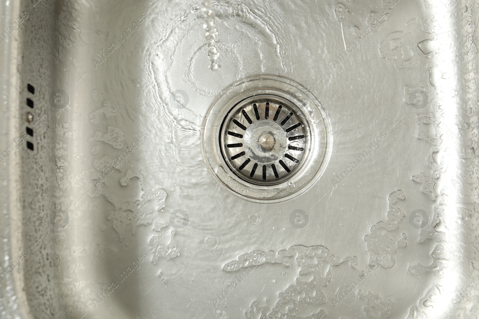 Water going down sink drain, top view Photo of Water going down sink drain, top view
