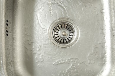 Photo of Water going down sink drain, top view