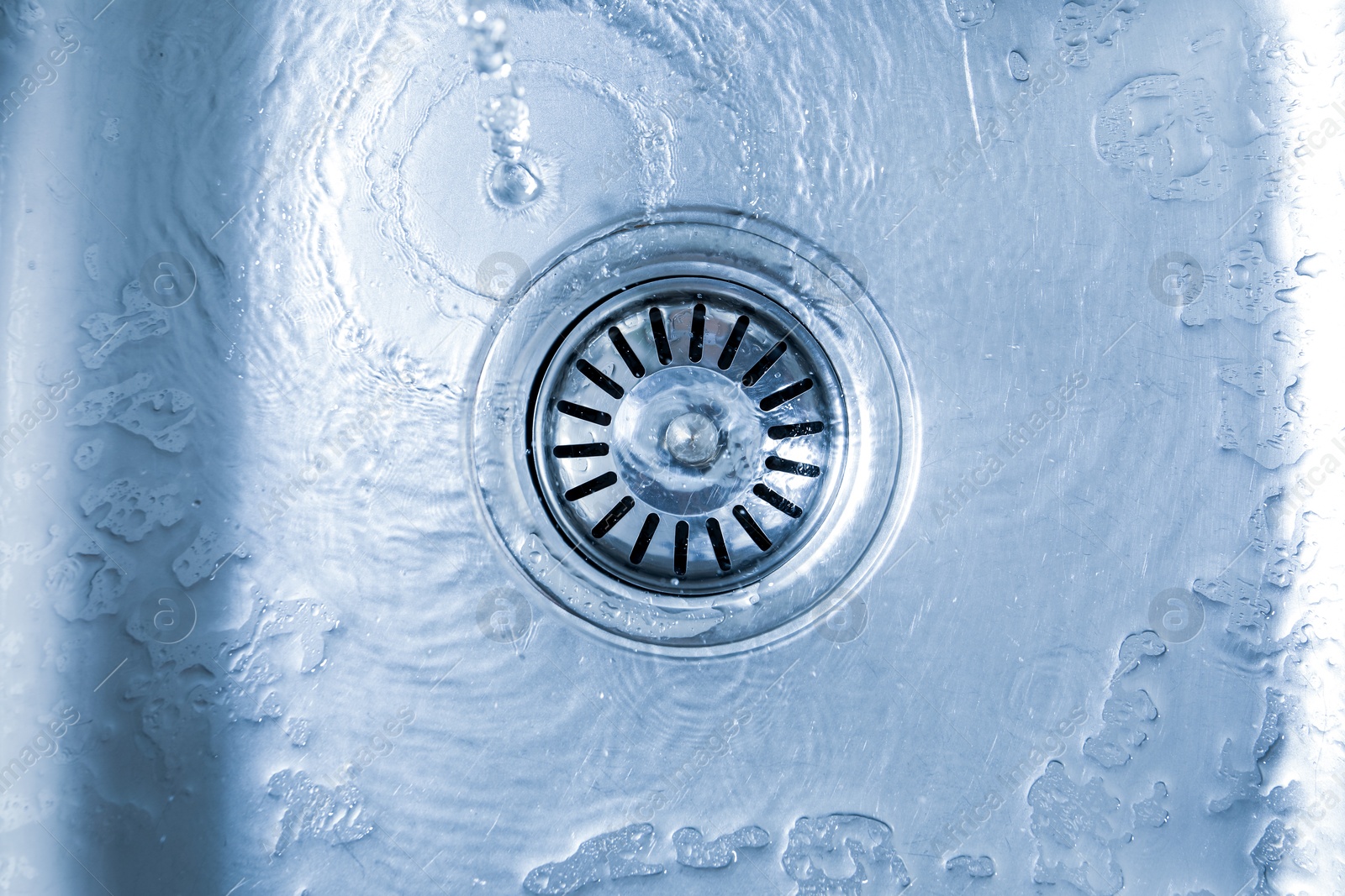 Photo of Water going down sink drain, top view