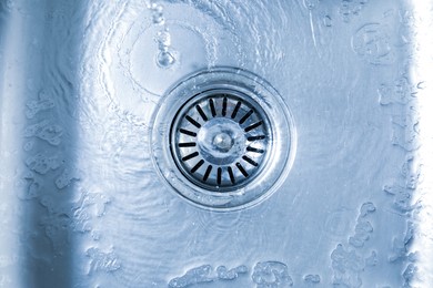 Photo of Water going down sink drain, top view