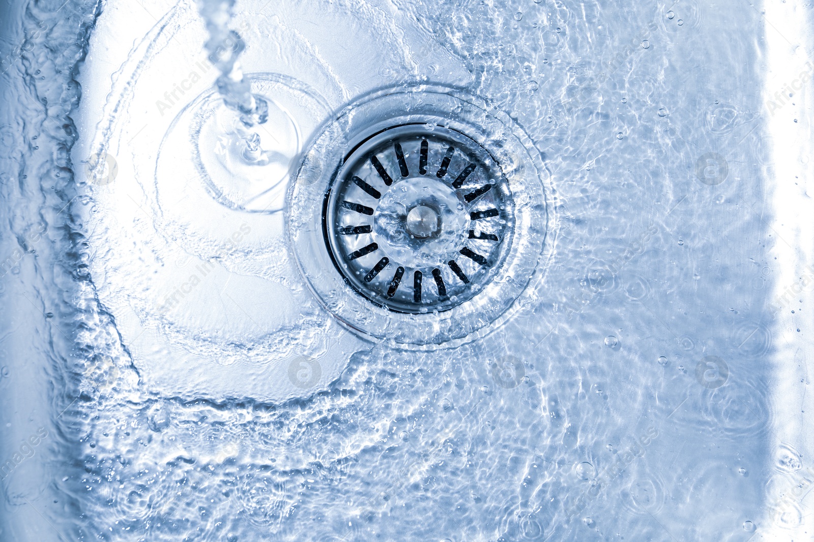 Water going down sink drain, top view Photo of Water going down sink drain, top view