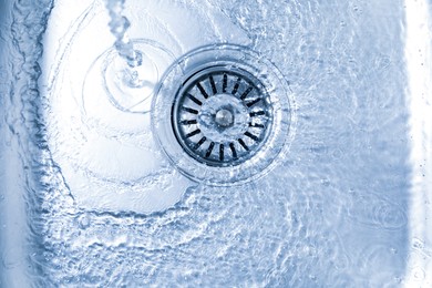 Photo of Water going down sink drain, top view