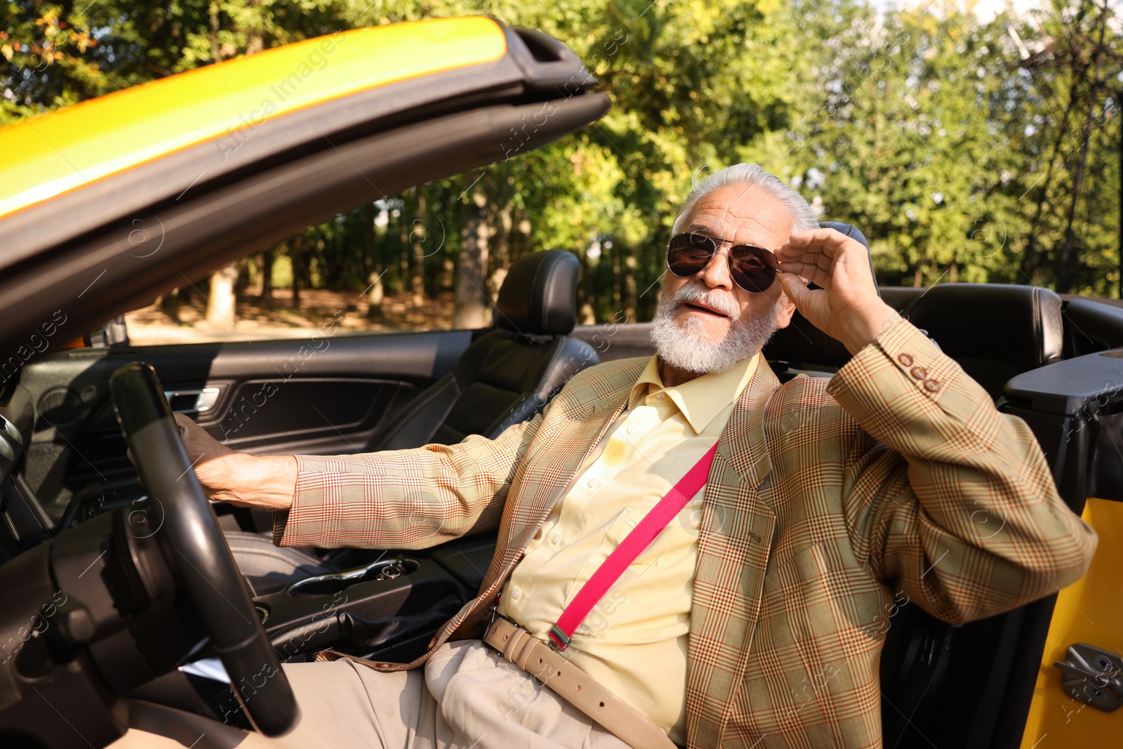Stylish senior man in sunglasses driving modern cabriolet outdoors Photo of Stylish senior man in sunglasses driving modern cabriolet outdoors