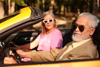 Photo of Senior couple enjoying cabriolet ride in city, selective focus