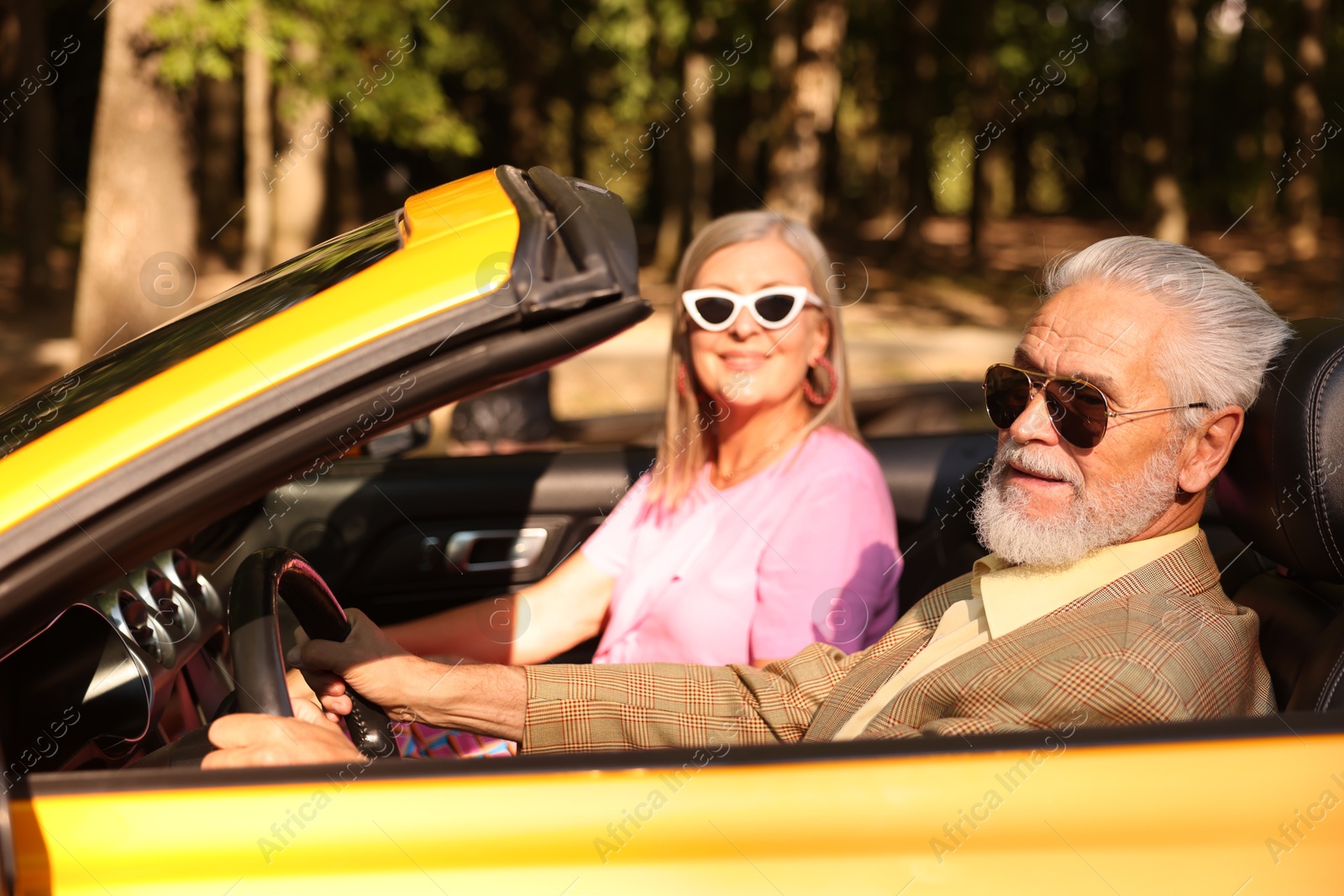 Photo of Senior couple enjoying cabriolet ride in city, selective focus