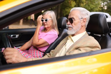 Photo of Senior couple enjoying cabriolet ride in city, selective focus