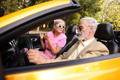 Photo of Senior couple enjoying cabriolet ride in city, selective focus