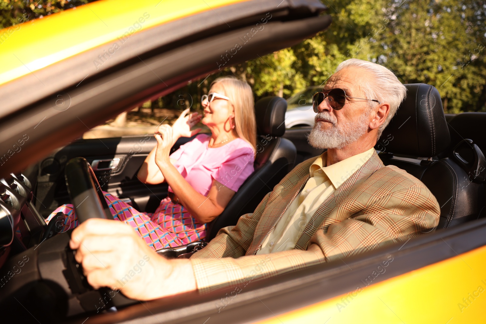 Senior couple enjoying cabriolet ride in city, selective focus Photo of Senior couple enjoying cabriolet ride in city, selective focus