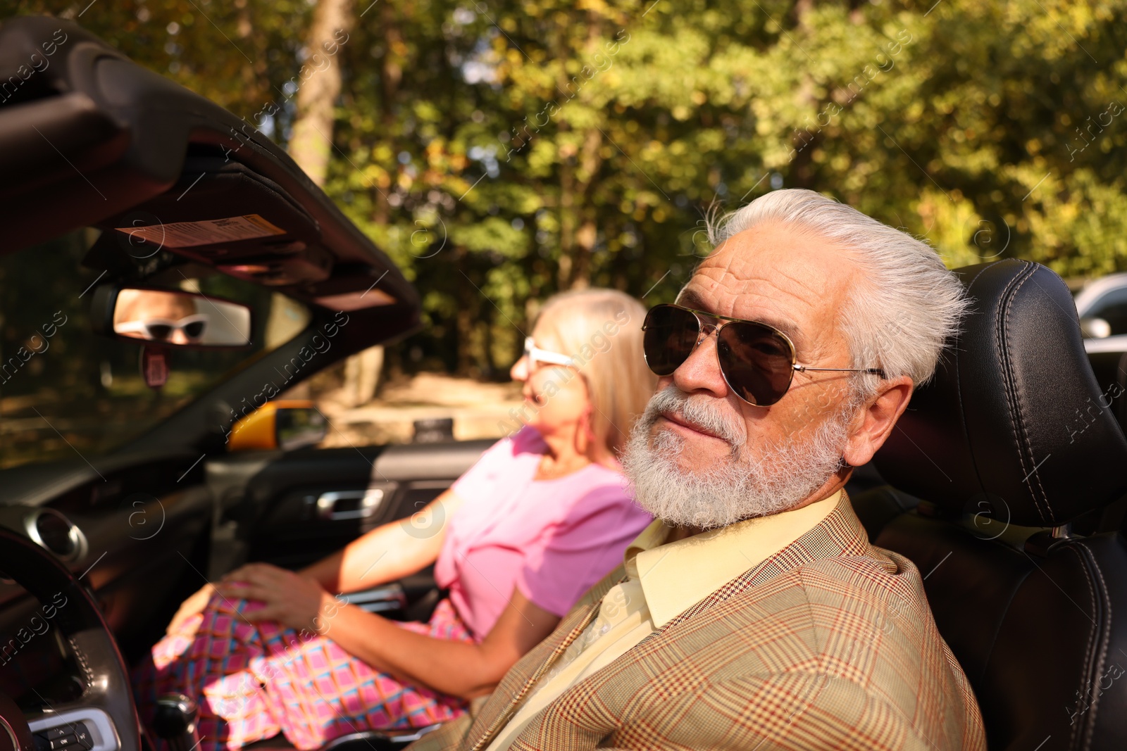 Senior couple enjoying cabriolet ride in city, selective focus Photo of Senior couple enjoying cabriolet ride in city, selective focus