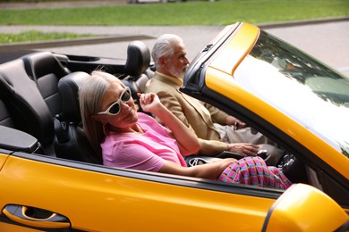 Photo of Senior couple enjoying cabriolet ride in city
