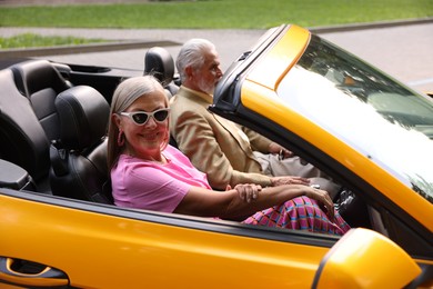 Photo of Senior couple enjoying cabriolet ride in city