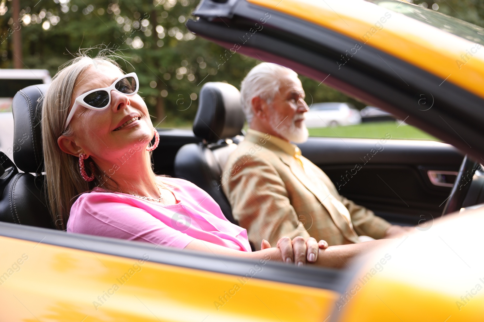Senior couple enjoying cabriolet ride in city, selective focus Photo of Senior couple enjoying cabriolet ride in city, selective focus