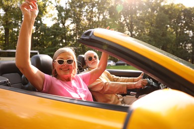 Photo of Senior couple enjoying cabriolet ride in city, selective focus