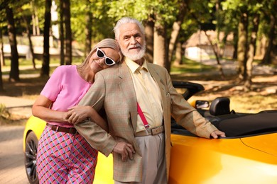 Photo of Stylish senior couple near modern cabriolet outdoors