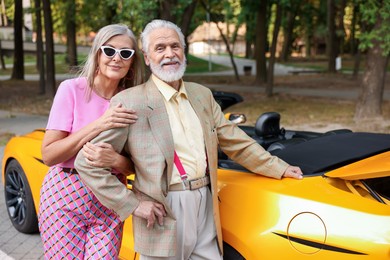 Photo of Stylish senior couple near modern cabriolet outdoors