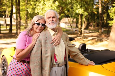 Photo of Stylish senior couple near modern cabriolet outdoors