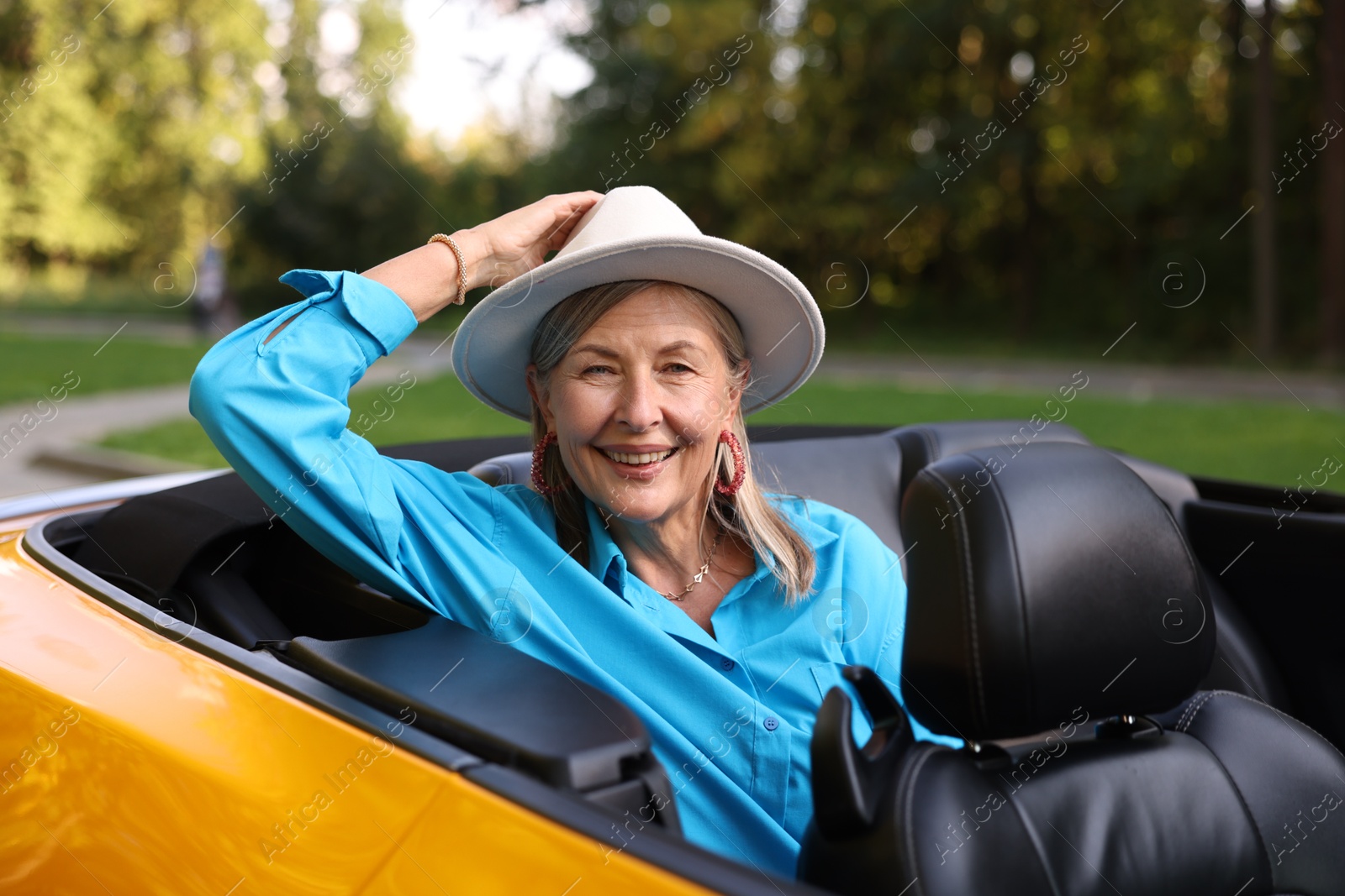 Photo of Stylish senior woman in modern cabriolet outdoors