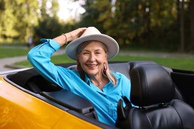 Photo of Stylish senior woman in modern cabriolet outdoors