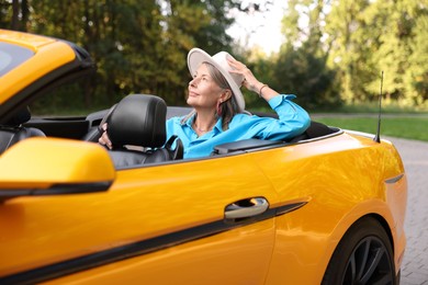 Photo of Stylish senior woman in modern cabriolet outdoors