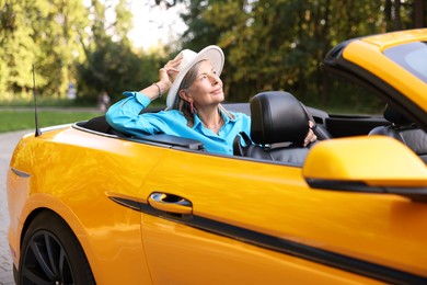 Photo of Stylish senior woman in modern cabriolet outdoors