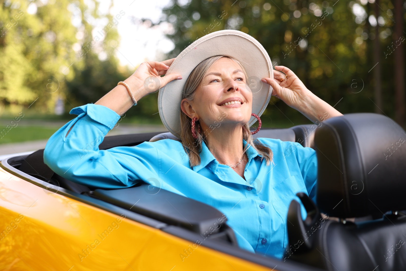 Photo of Stylish senior woman in modern cabriolet outdoors