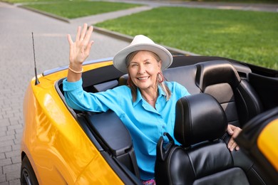 Photo of Stylish senior woman in modern cabriolet outdoors