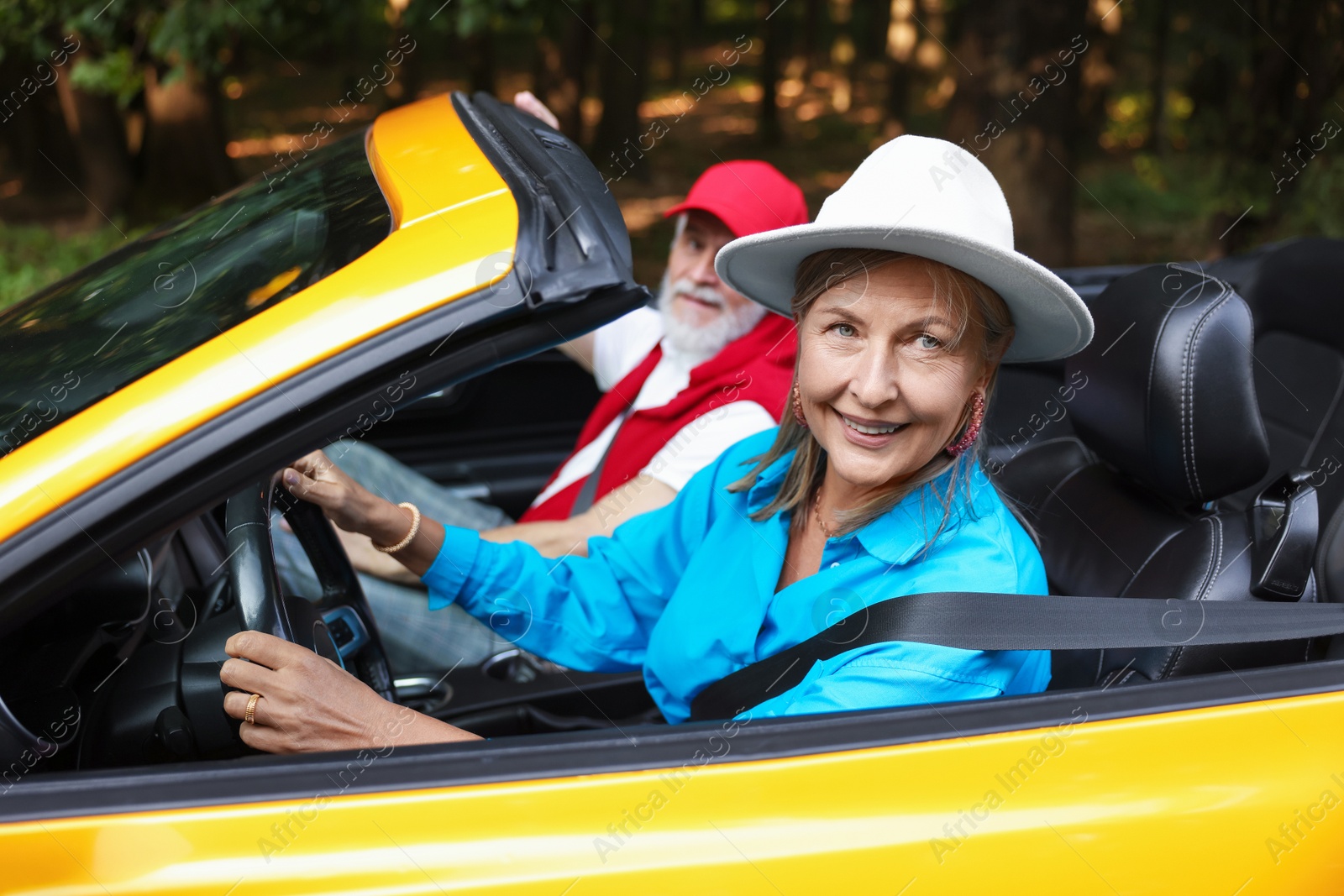 Photo of Senior couple enjoying cabriolet ride outdoors, selective focus