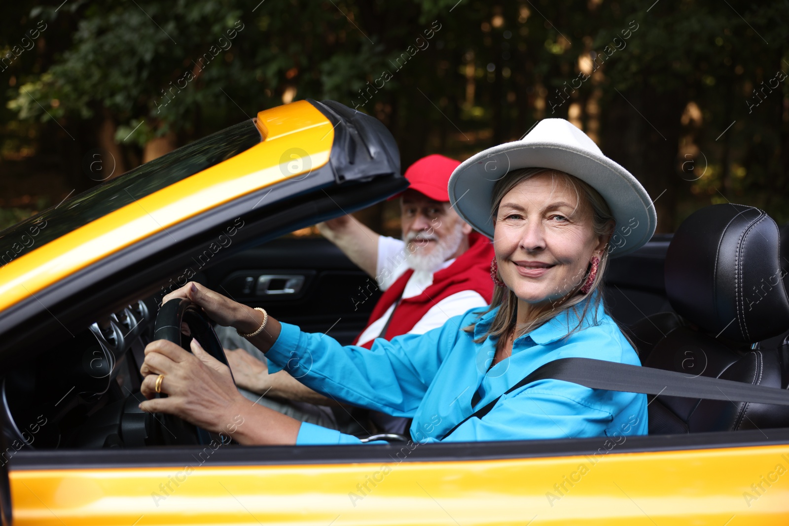 Photo of Senior couple enjoying cabriolet ride outdoors, selective focus