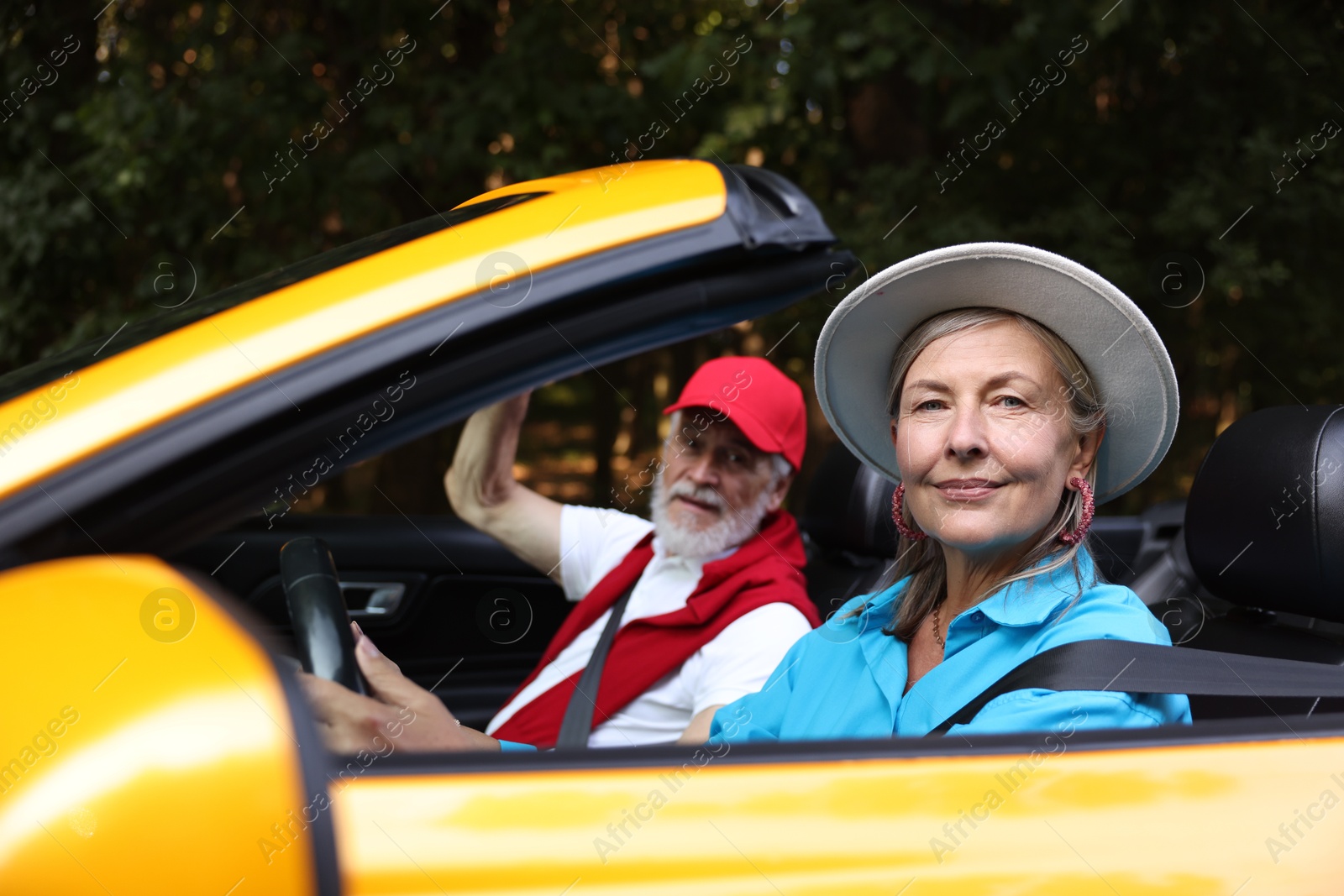 Photo of Senior couple enjoying cabriolet ride outdoors, selective focus