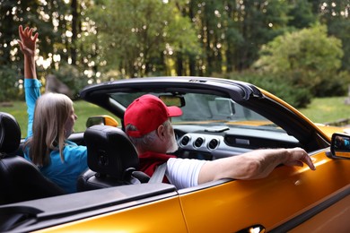 Photo of Stylish senior couple enjoying cabriolet ride outdoors