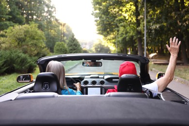 Photo of Senior couple enjoying cabriolet ride outdoors, back view