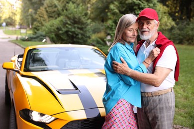 Photo of Stylish senior couple near modern cabriolet outdoors