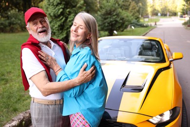 Photo of Stylish senior couple near modern cabriolet outdoors