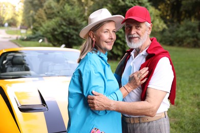Photo of Stylish senior couple near modern cabriolet outdoors