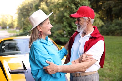 Photo of Stylish senior couple near modern cabriolet outdoors