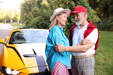 Photo of Stylish senior couple near modern cabriolet outdoors