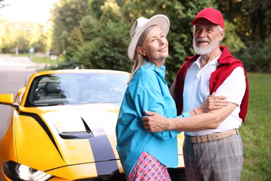 Photo of Stylish senior couple near modern cabriolet outdoors