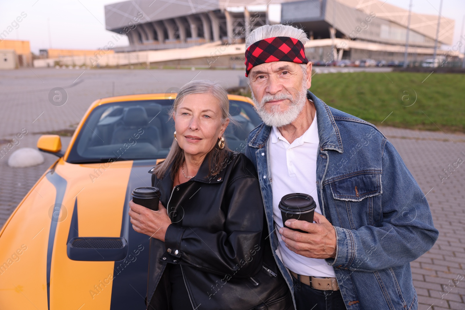 Stylish senior couple with takeaway coffee near modern cabriolet outdoors Photo of Stylish senior couple with takeaway coffee near modern cabriolet outdoors